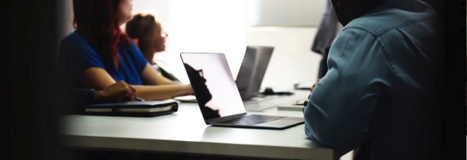 People at a desk on their laptops
